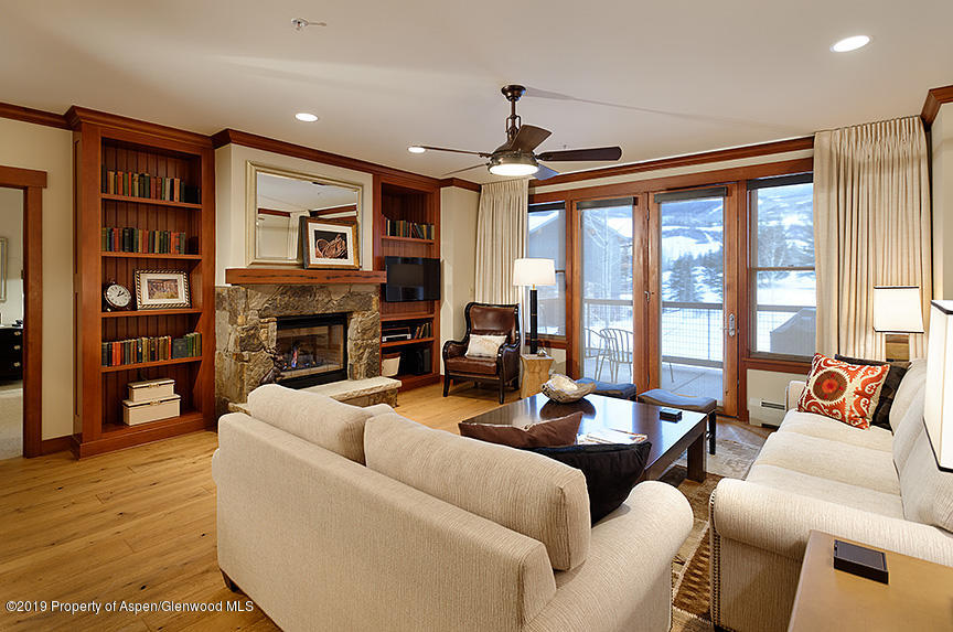 a living room with furniture fireplace and a large window