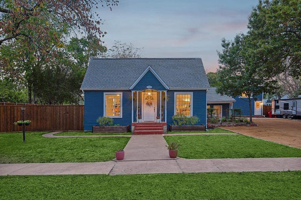 a front view of a house with a yard and trees