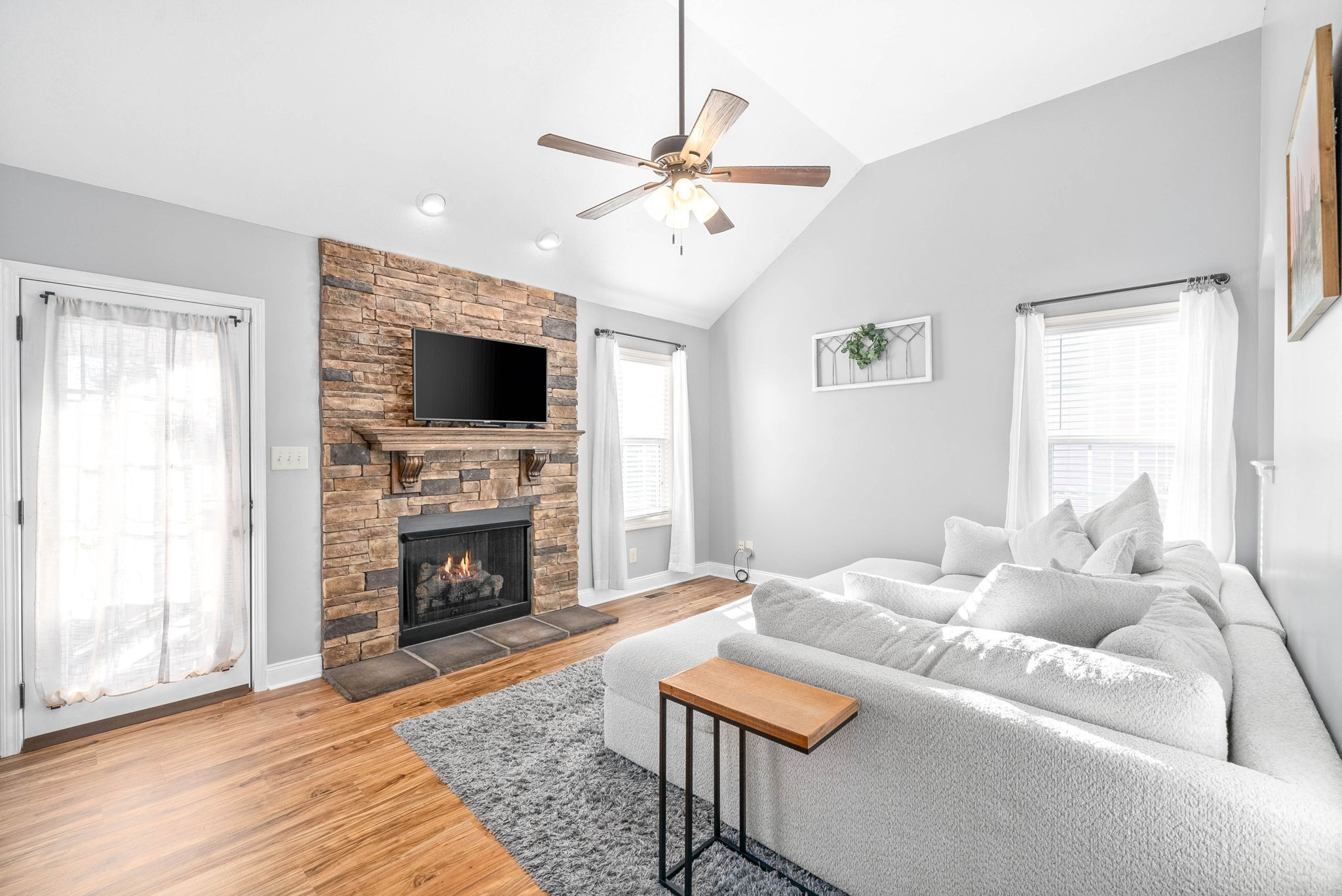 a living room with furniture a fireplace and a flat screen tv