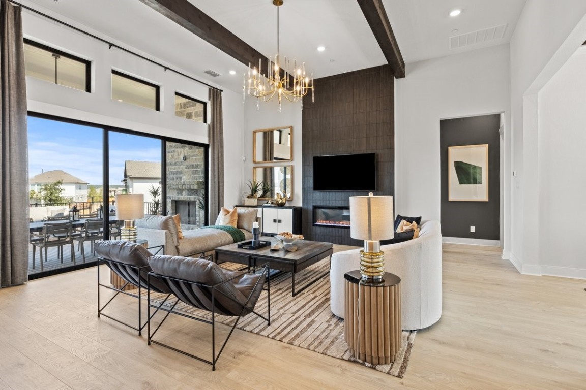 a living room with furniture a flat screen tv and a floor to ceiling window