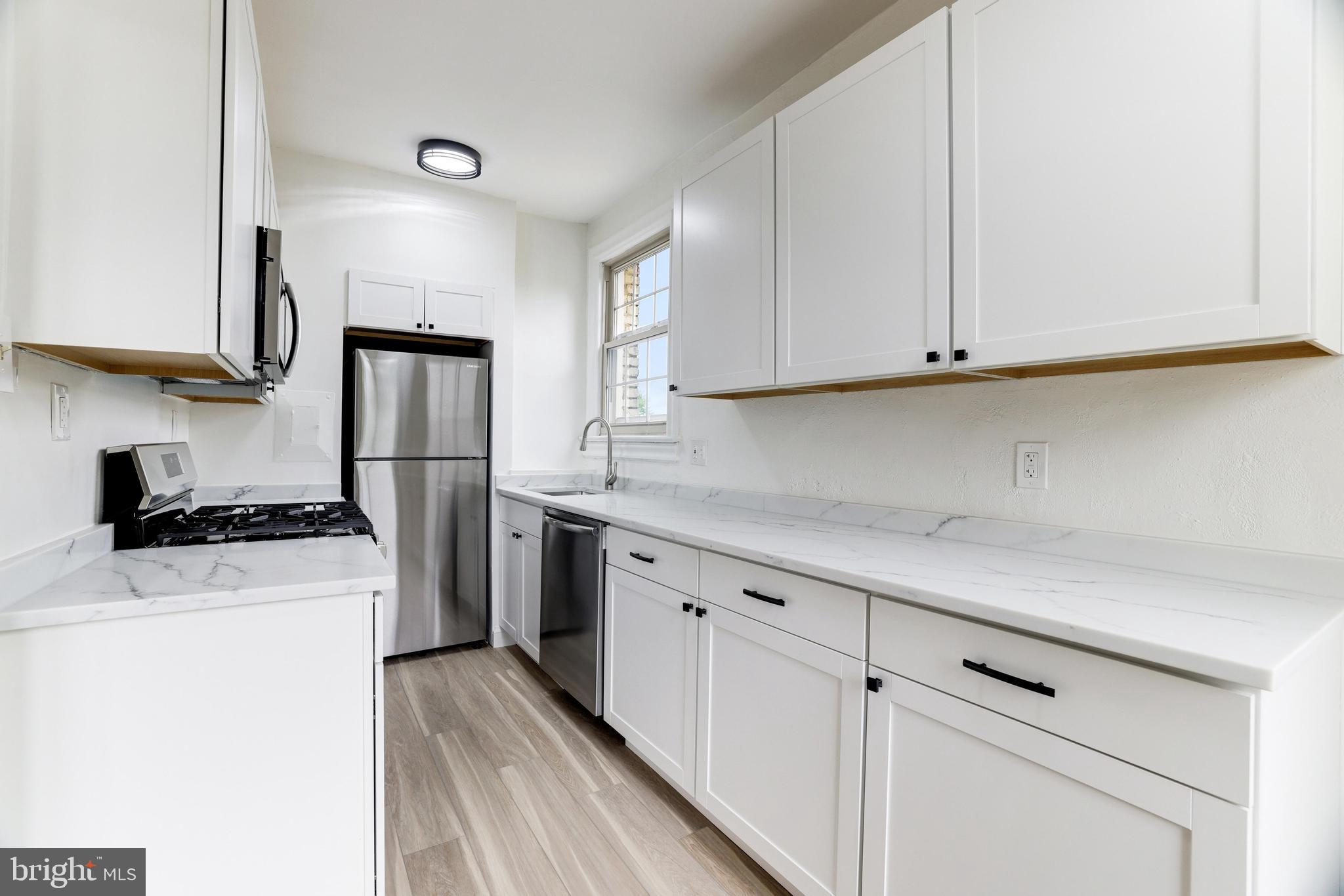 a kitchen with white cabinets and white appliances