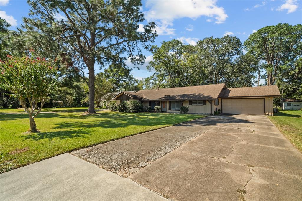 a view of a house with a big yard and large trees