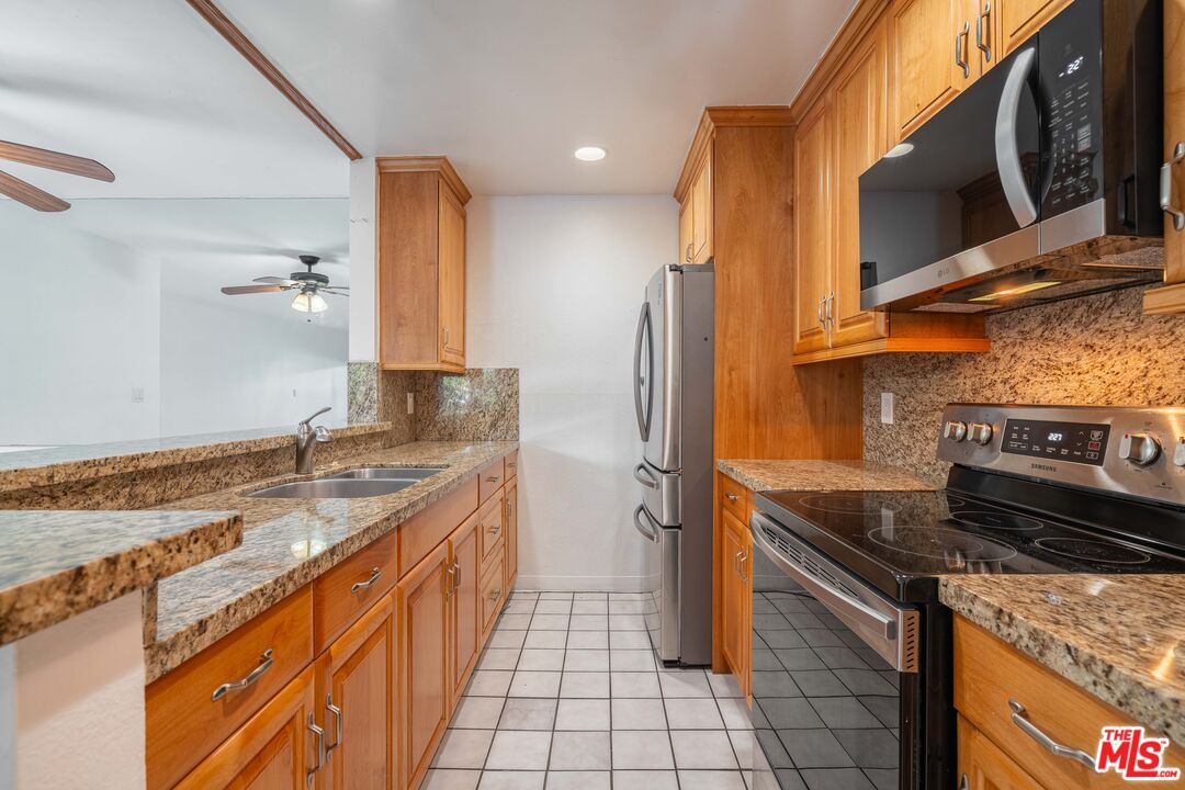 a kitchen with stainless steel appliances granite countertop a sink and a stove