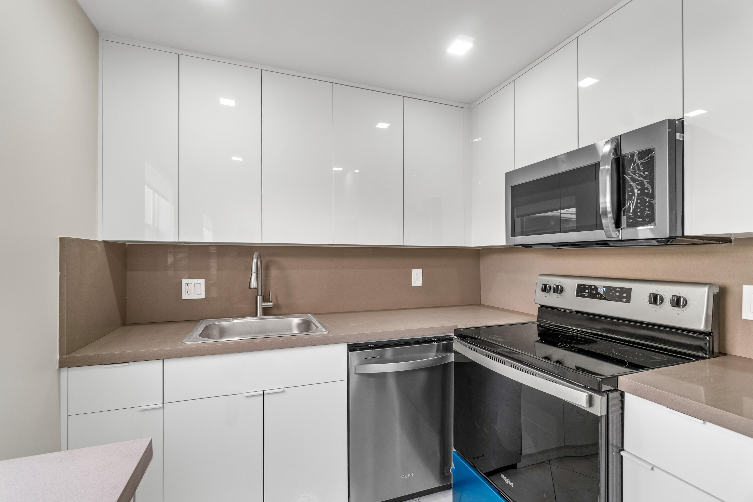 a kitchen with a sink and a stove top oven with wooden floor