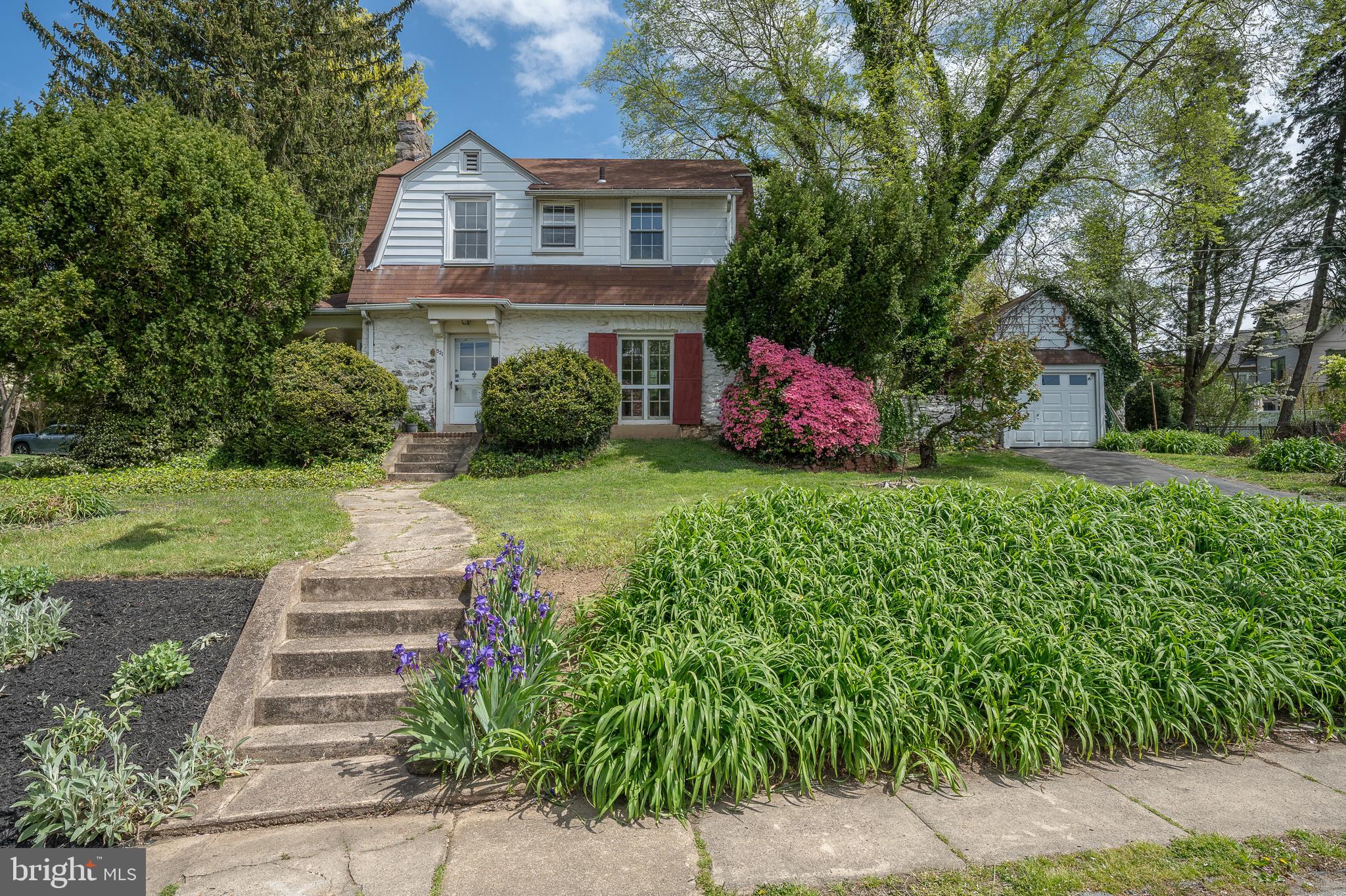 a front view of a house with a yard and trees