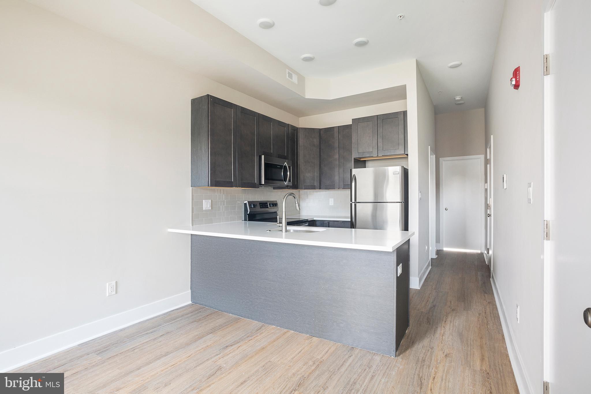 a view of kitchen with stainless steel appliances cabinets