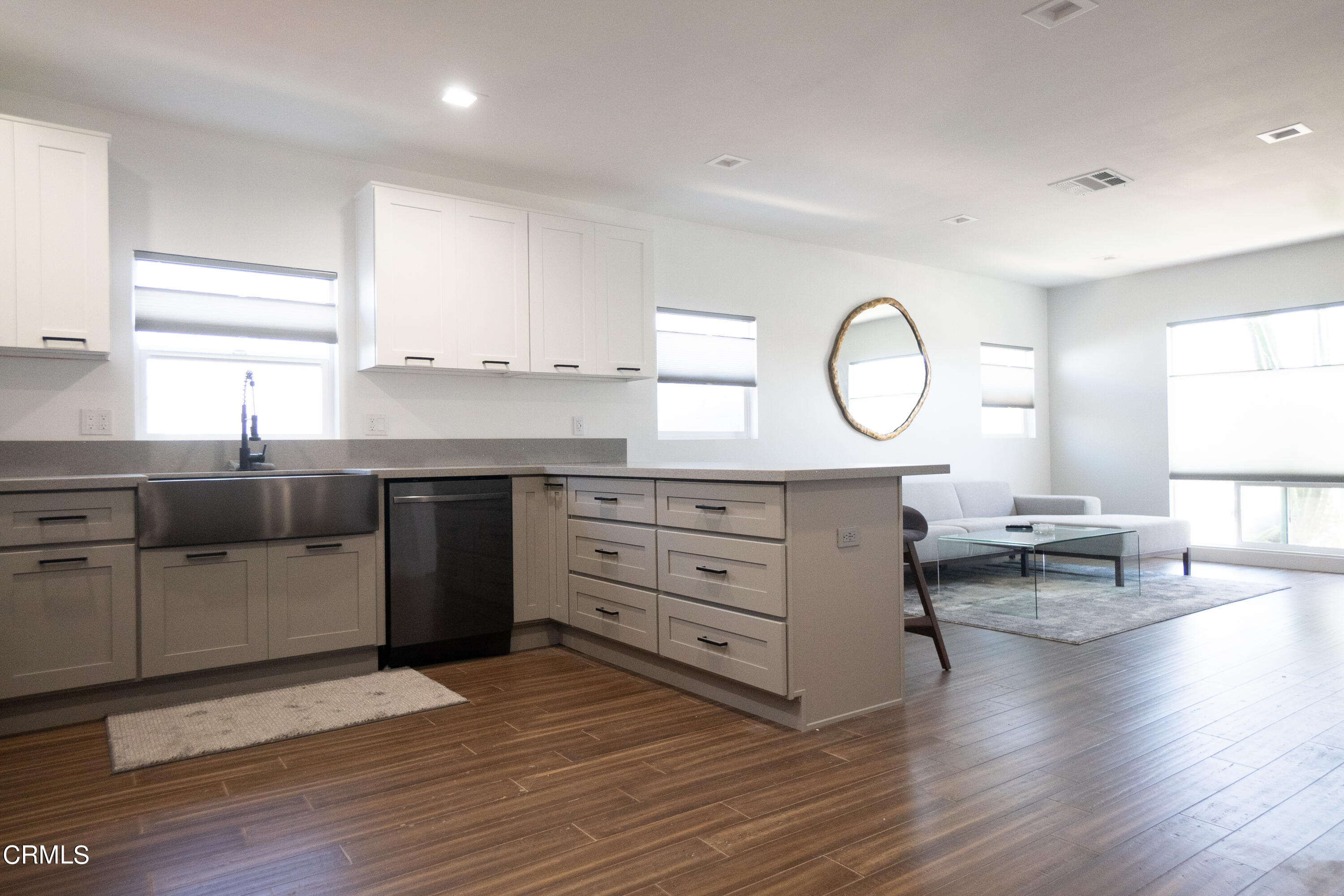 a kitchen with a sink a stove cabinets and wooden floor