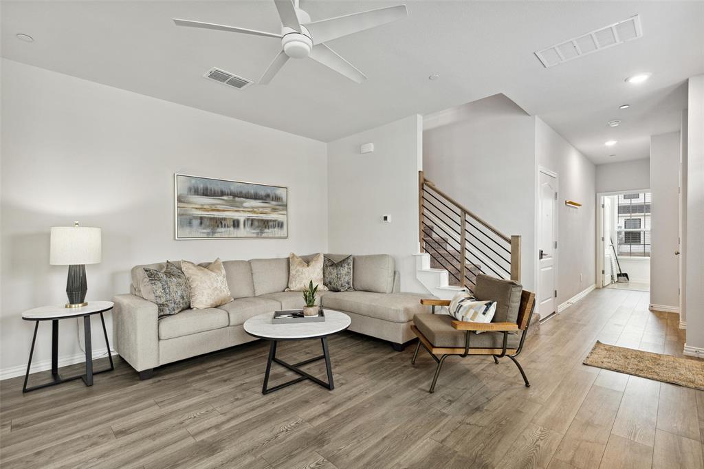 a living room with furniture and a wooden floor