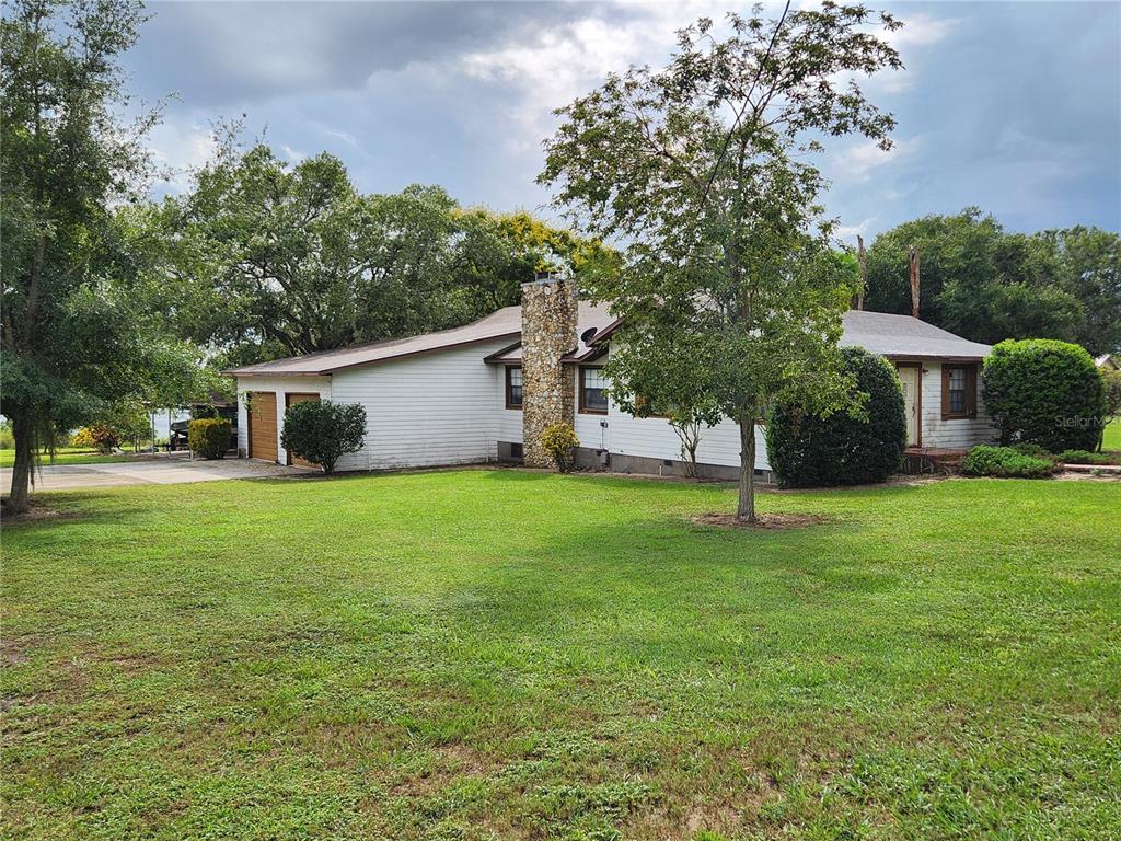 a front view of a house with a yard and trees