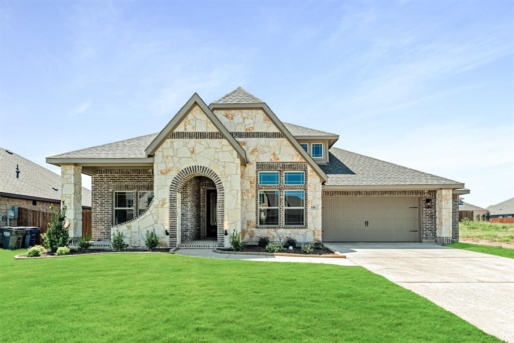 a front view of a house with a garden and yard