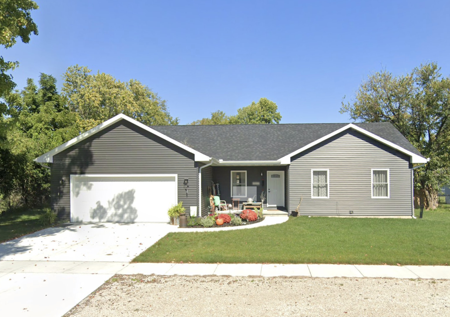 a front view of a house with a yard and trees