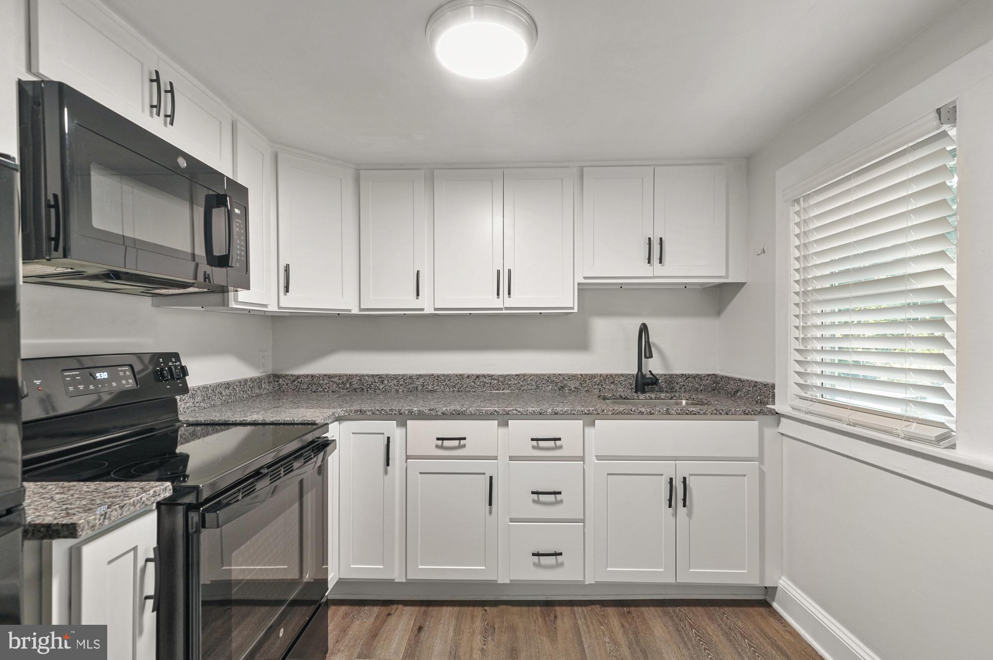 a kitchen with granite countertop a sink and cabinets