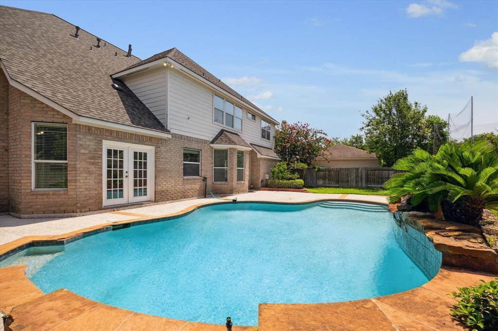 a view of a house with swimming pool and sitting area