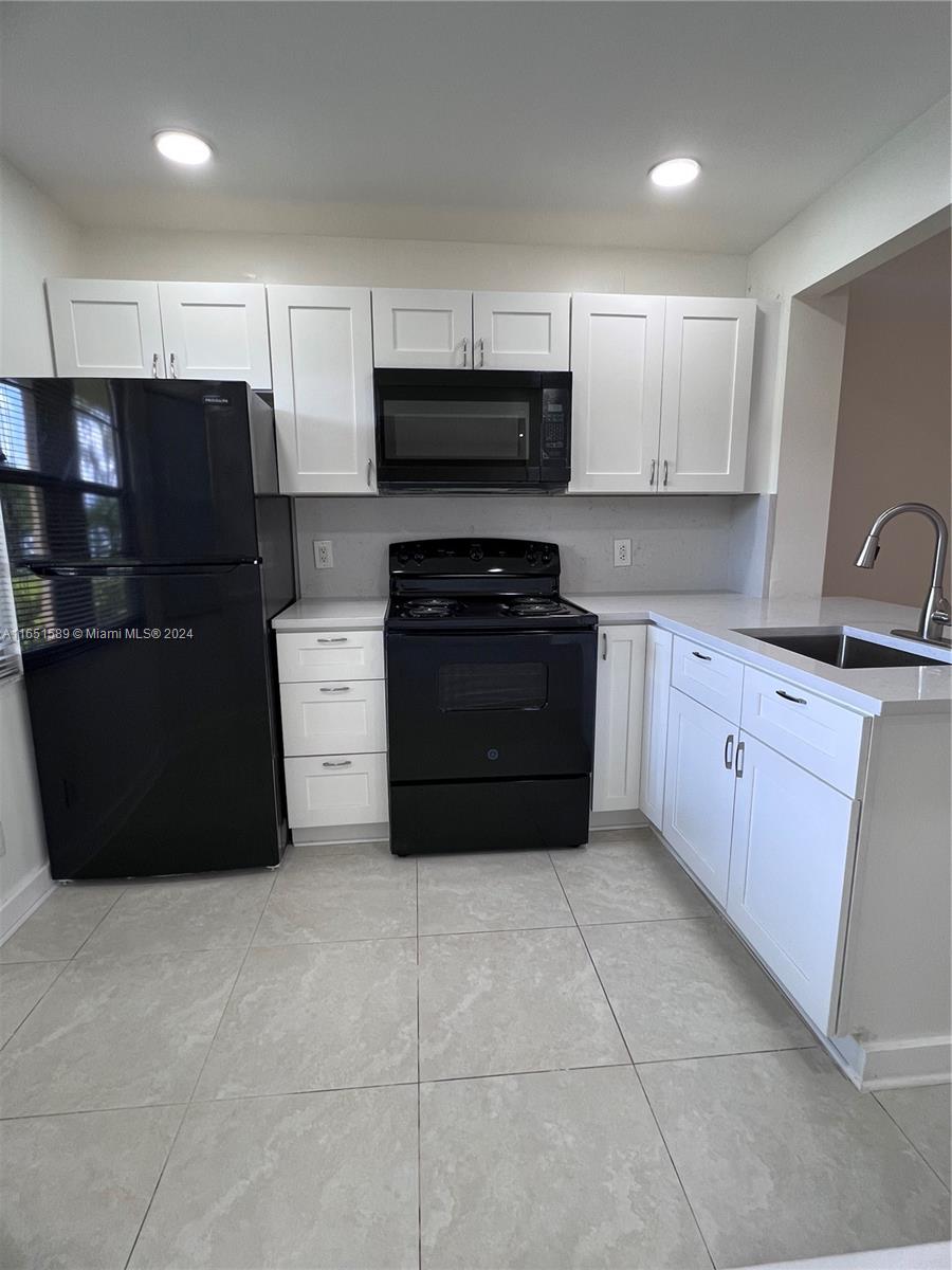 a kitchen with stainless steel appliances granite countertop a refrigerator and a stove