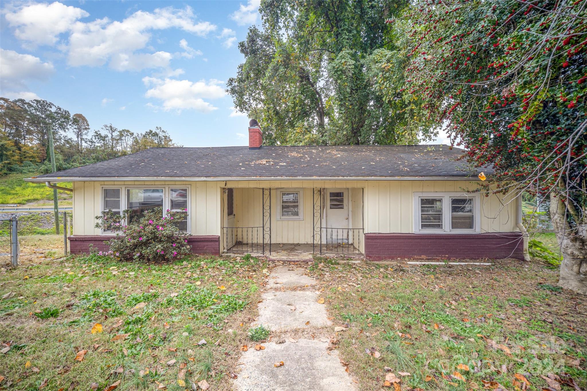 a front view of house with yard and trees in the background