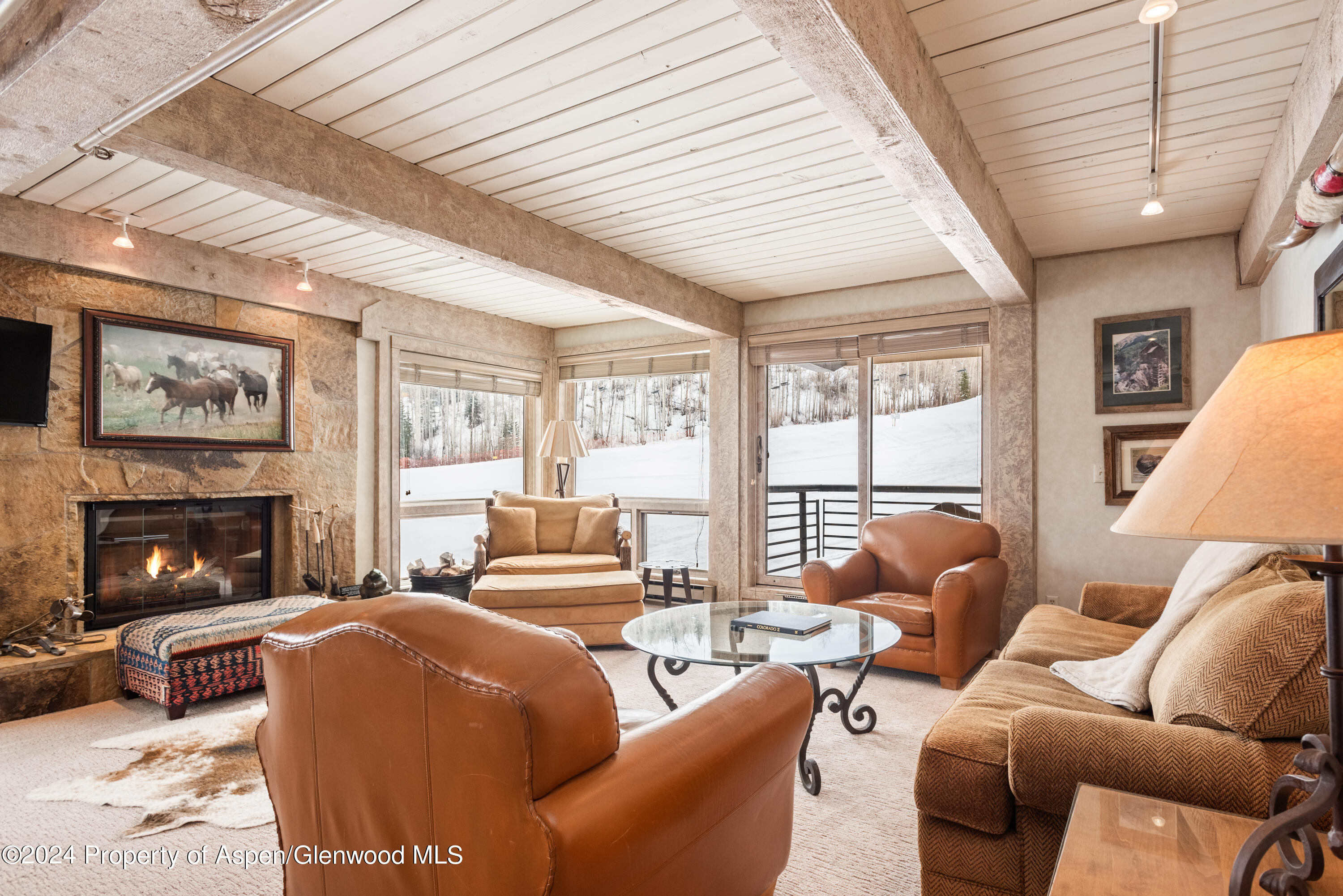 a living room with furniture a fireplace and a large window