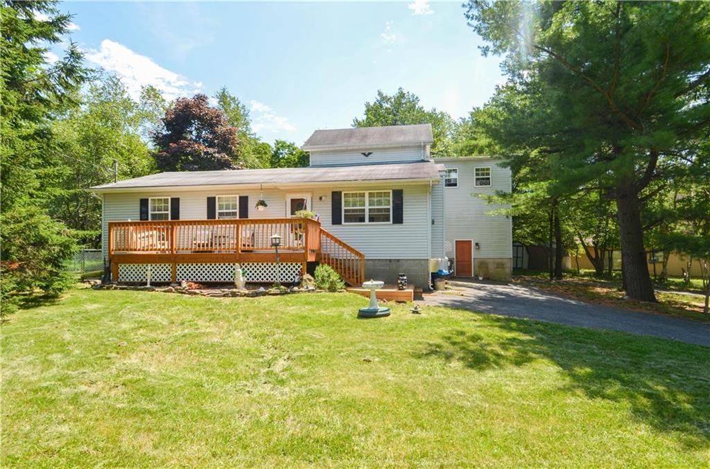 a view of a house with a yard patio and a tree