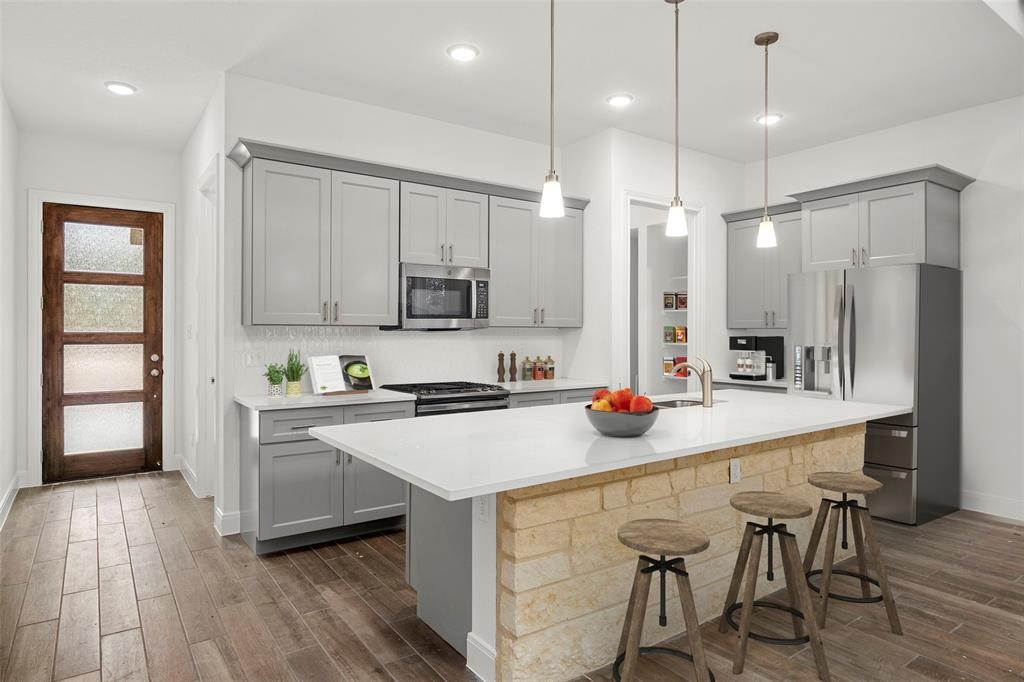 a kitchen that has a lot of cabinets in it and appliances