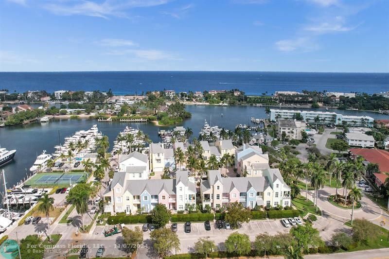 an aerial view of a city with lots of residential buildings ocean and mountain view in back