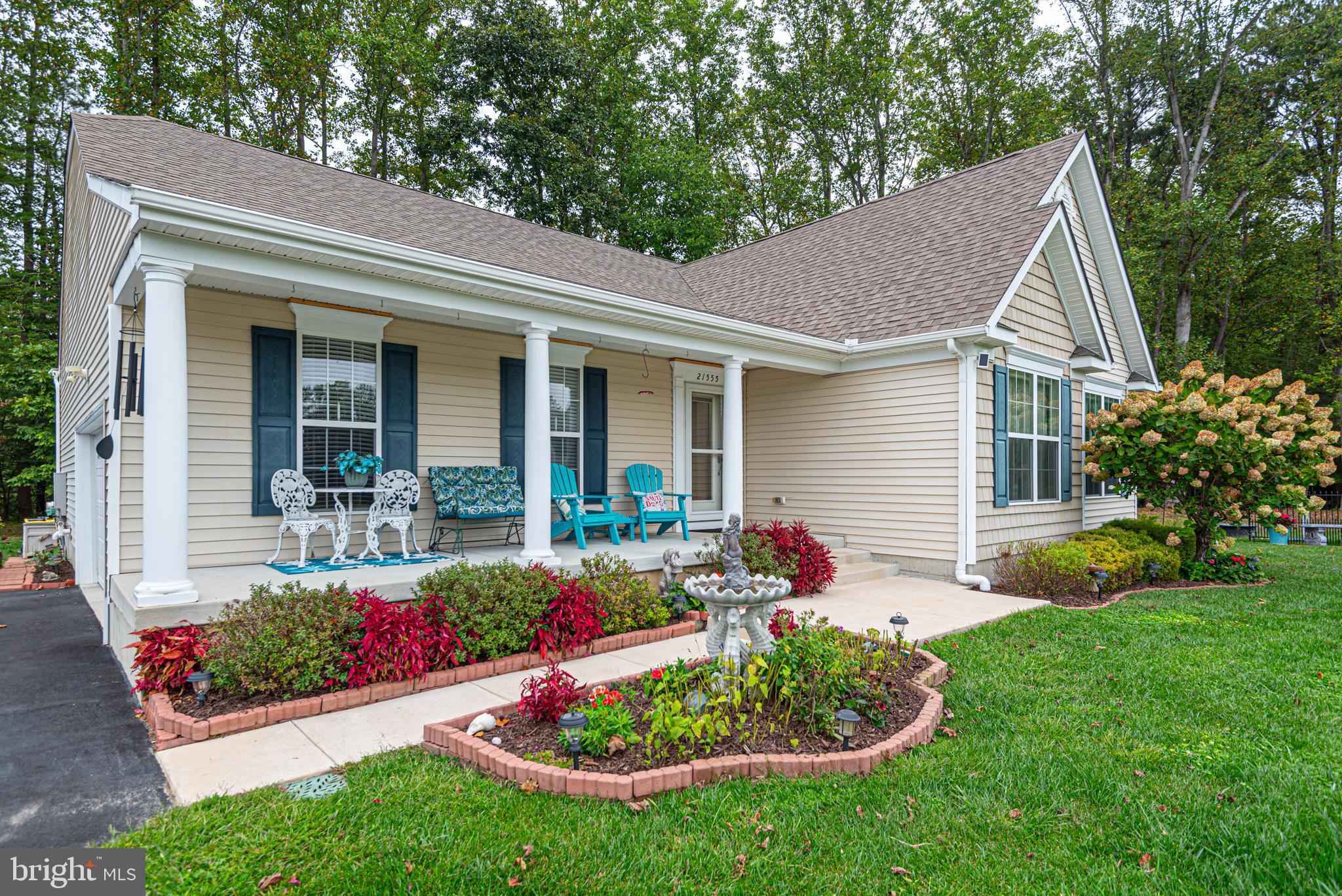 a front view of a house with a yard and potted plants