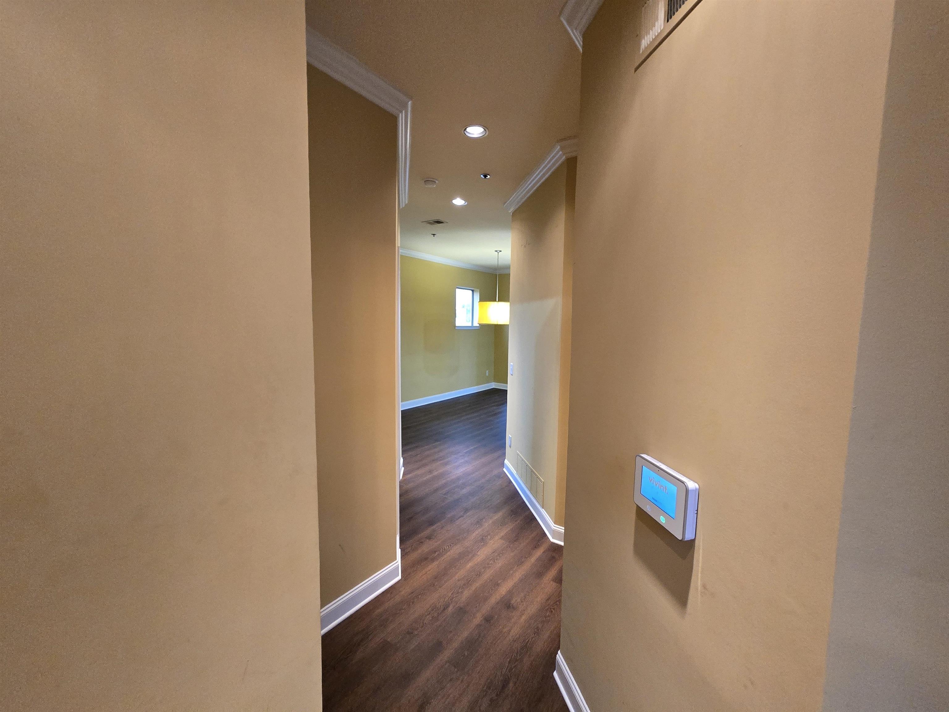 a view of a hallway with wooden floor