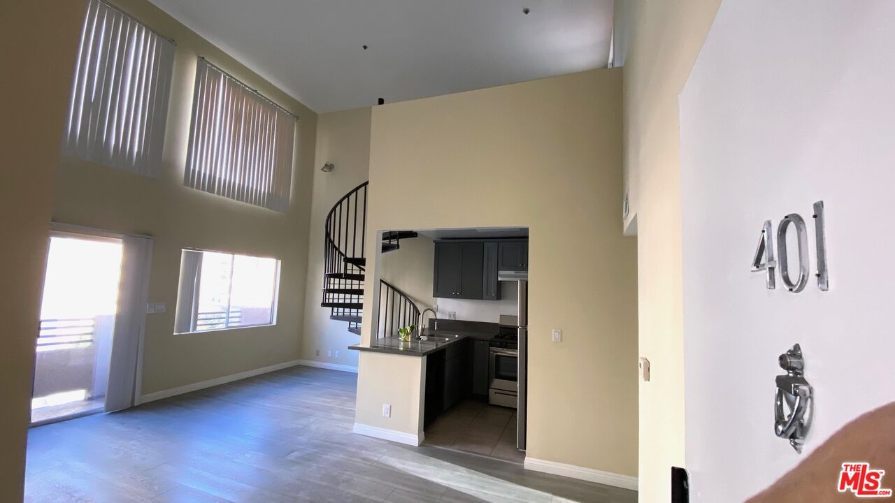 a hallway with wooden floor and windows