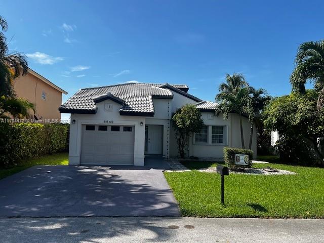 a front view of a house with a yard and garage