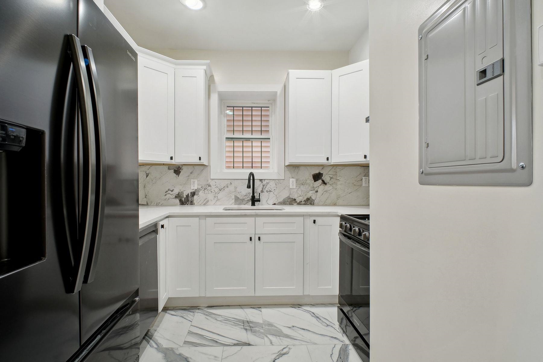 a kitchen with stainless steel appliances a sink cabinets and a refrigerator