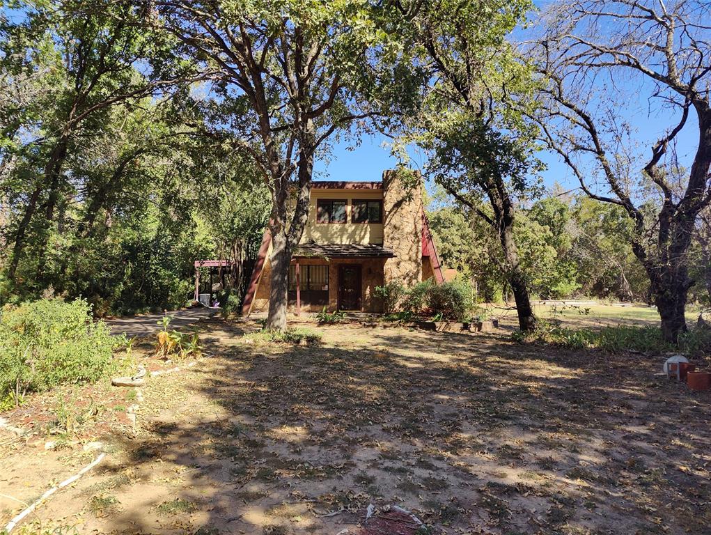 a front view of a house with a tree