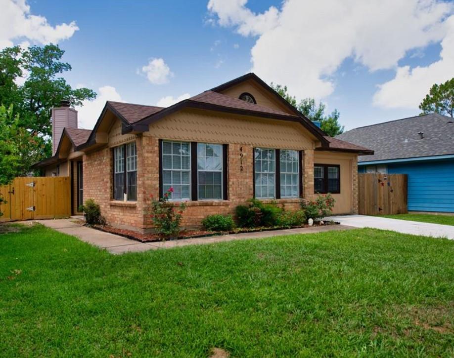 a front view of a house with a yard and outdoor seating