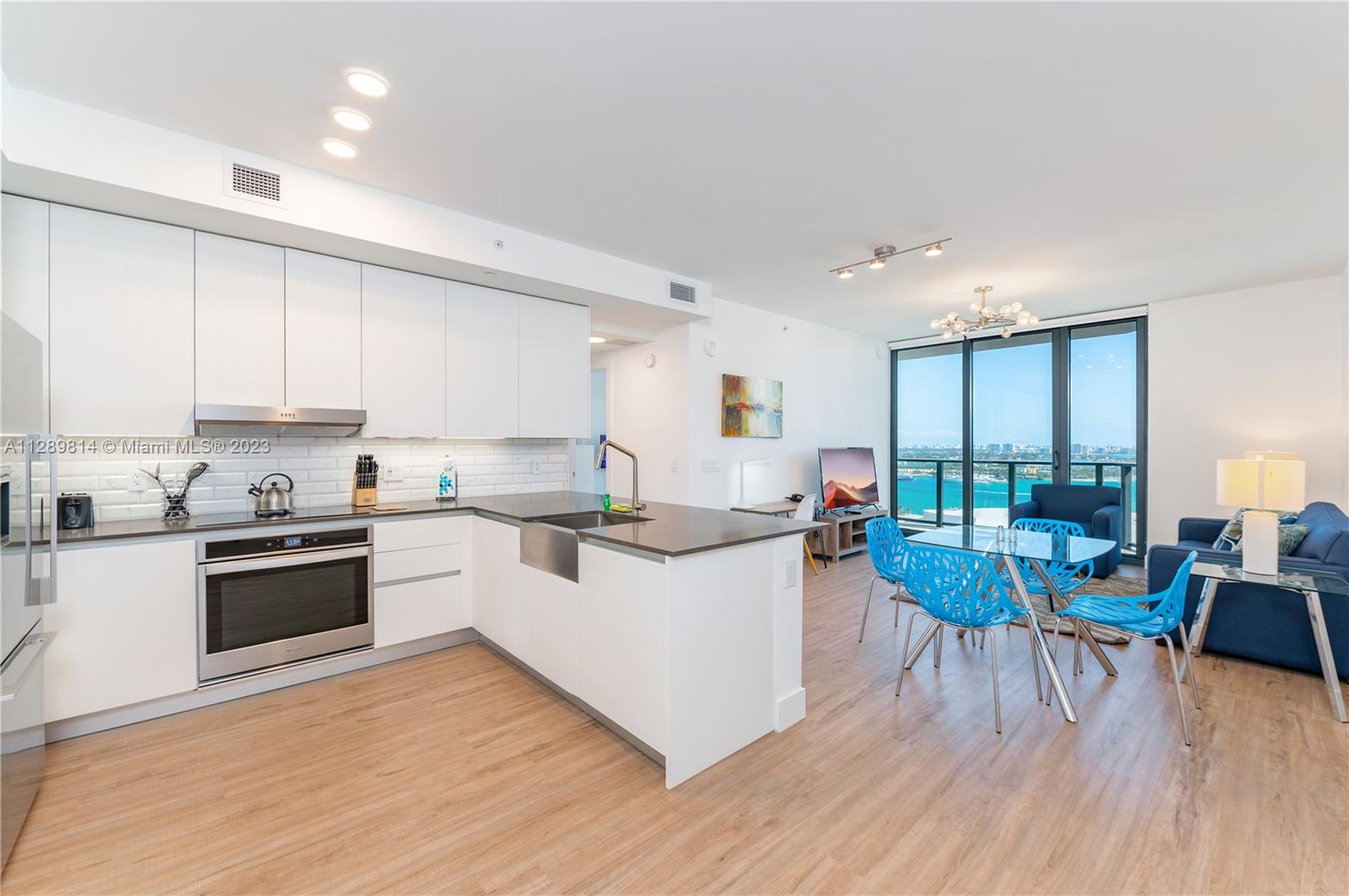 a kitchen with a table chairs stove and white cabinets