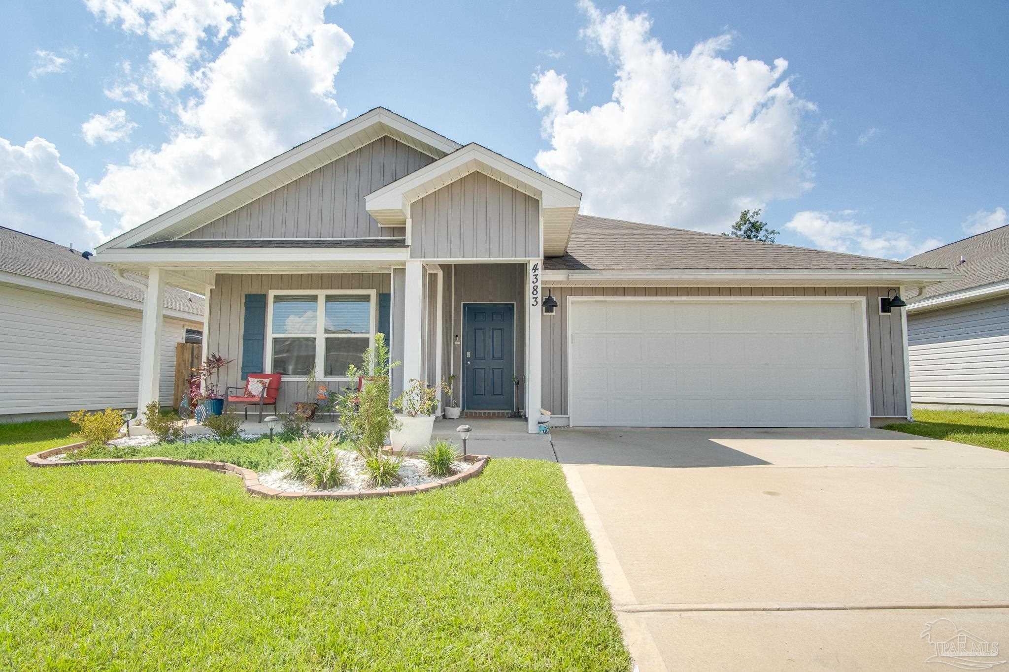 a front view of a house with a yard outdoor seating and garage