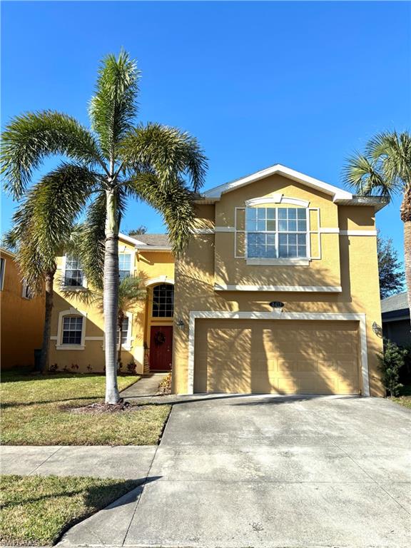 View of front of home featuring a front yard and a garage