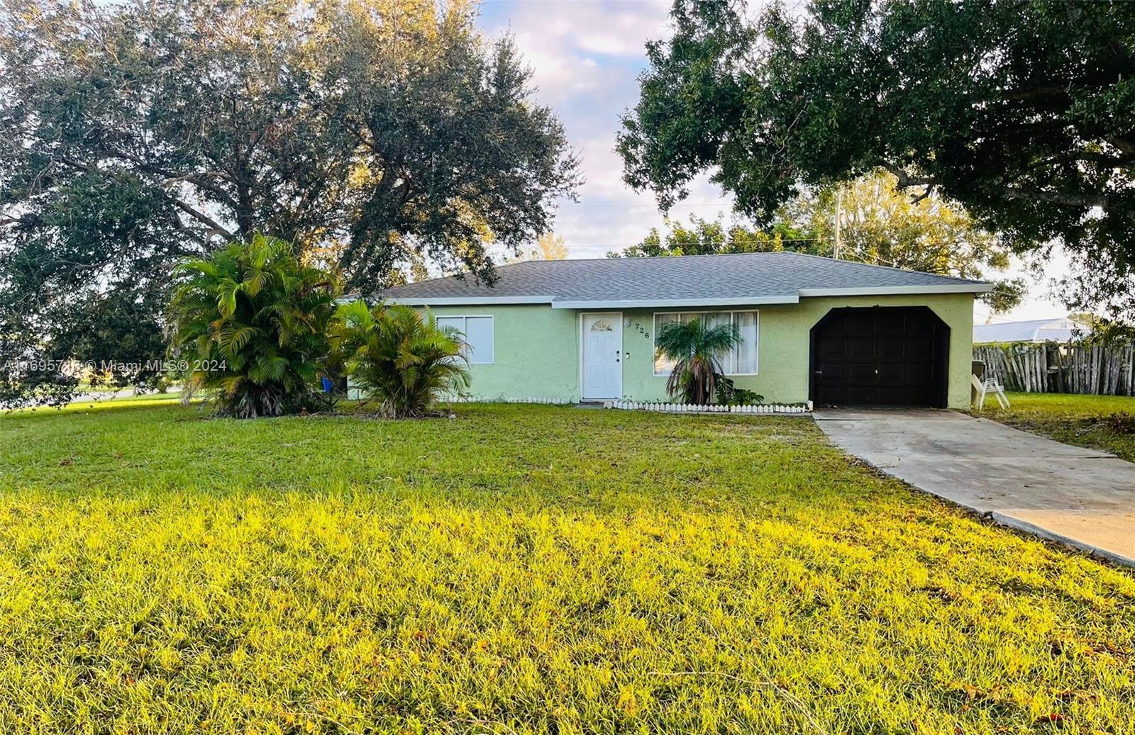 a view of a house with a yard and tree s