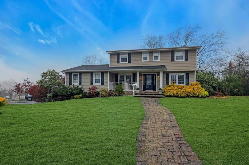 View of front facade with covered porch and a front yard