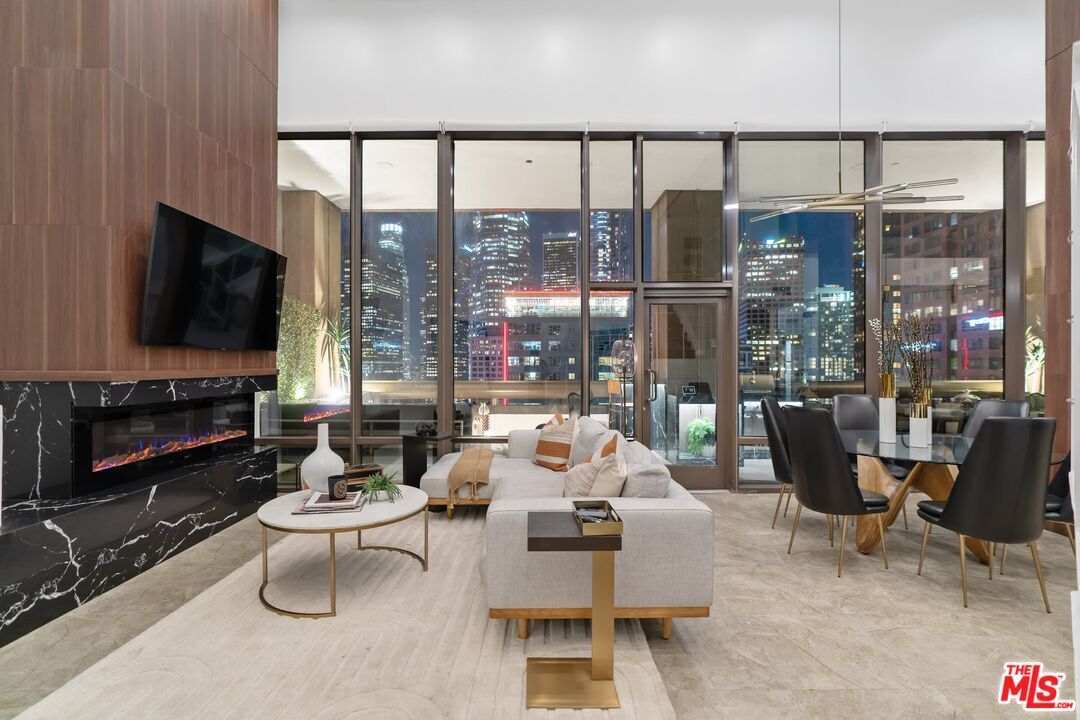 a living room with furniture a flat screen tv and a floor to ceiling window