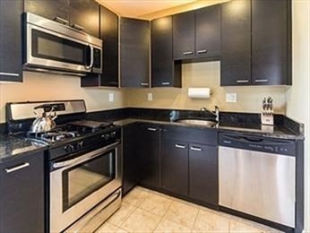 a kitchen with stainless steel appliances wooden cabinets and a stove top oven