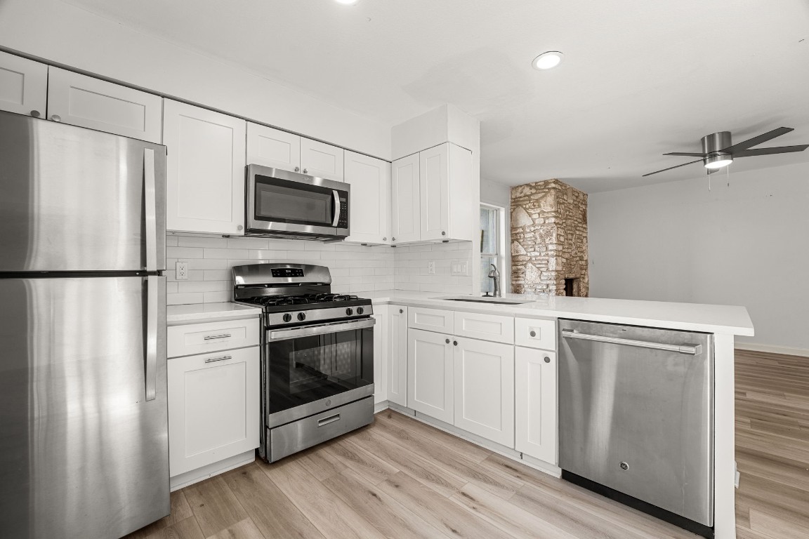 a kitchen with stainless steel appliances white cabinets and a refrigerator