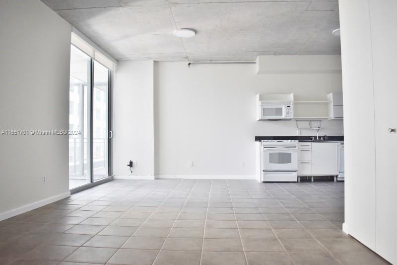 a view of kitchen with sink and refrigerator