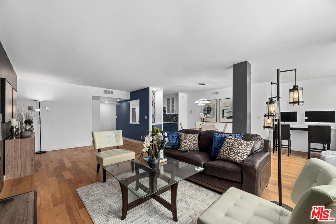 a living room with furniture and view of kitchen