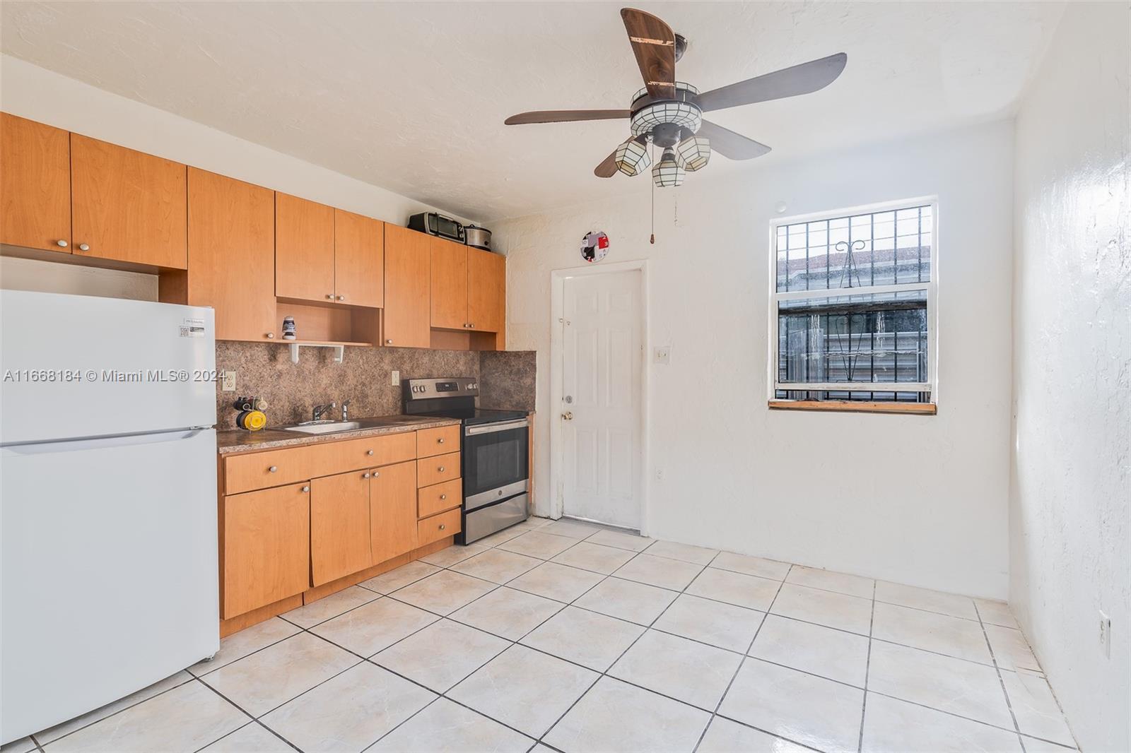 a kitchen with a refrigerator a stove top oven and cabinets