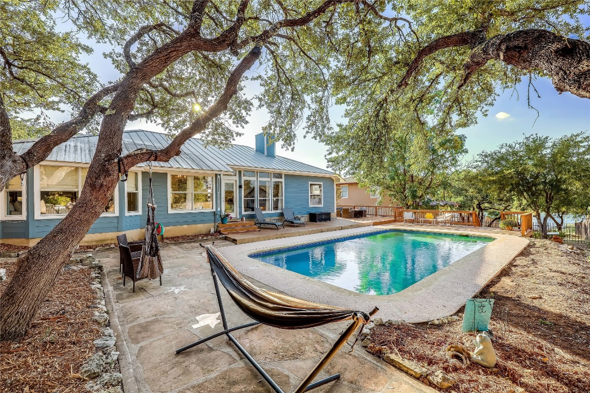 a view of house with swimming pool and sitting area