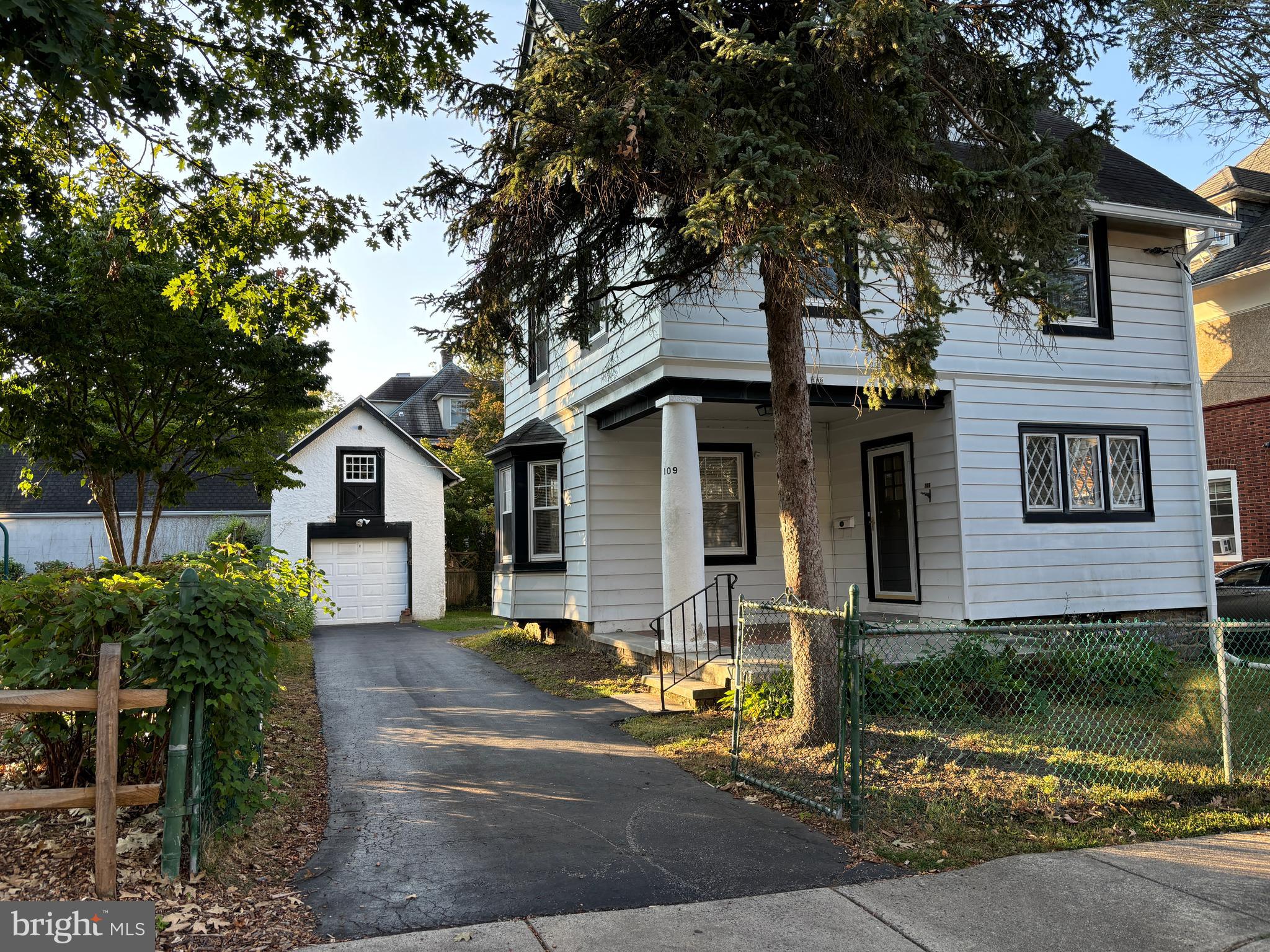 a front view of a house with a tree