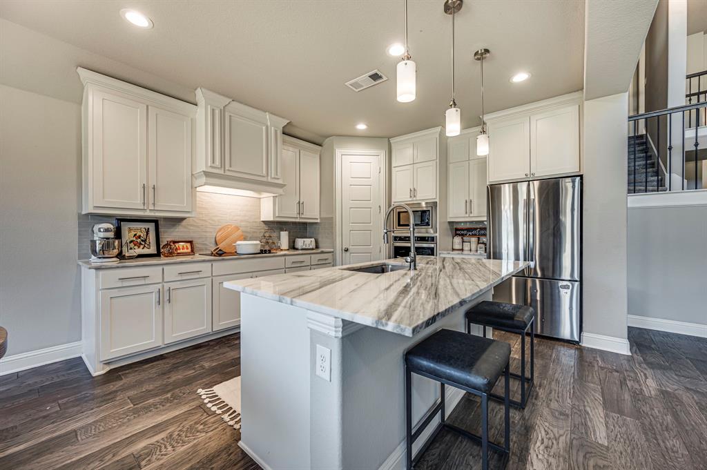 a kitchen with refrigerator cabinets and wooden floor