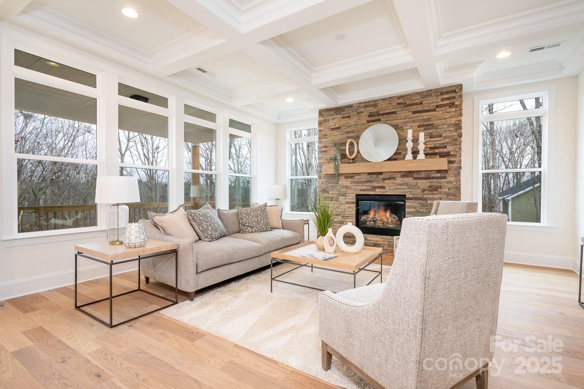 a living room with furniture a fireplace and a large window