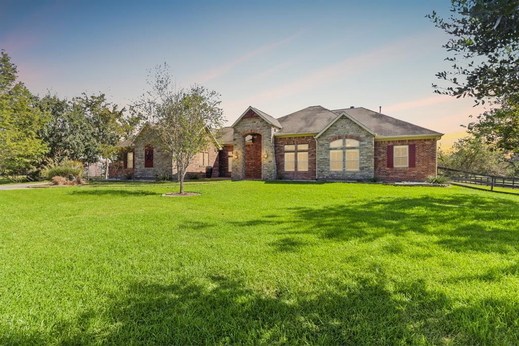 a view of a house with a big yard and large trees