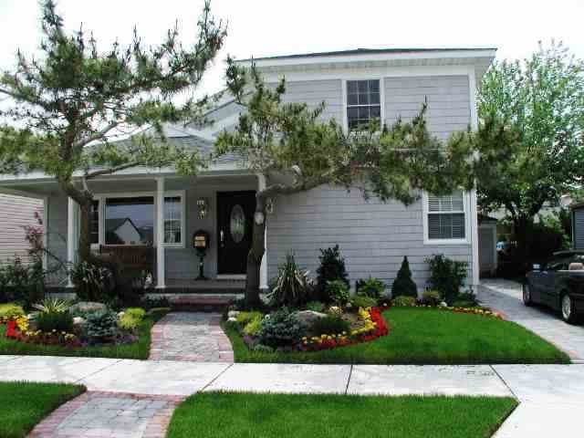 a front view of a house with a yard and potted plants