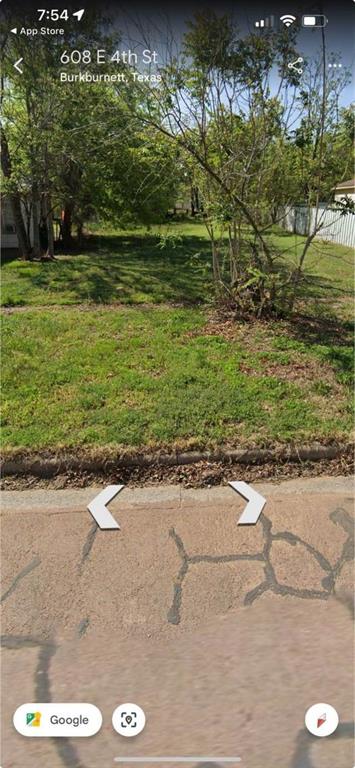 a view of a yard with a wooden fence