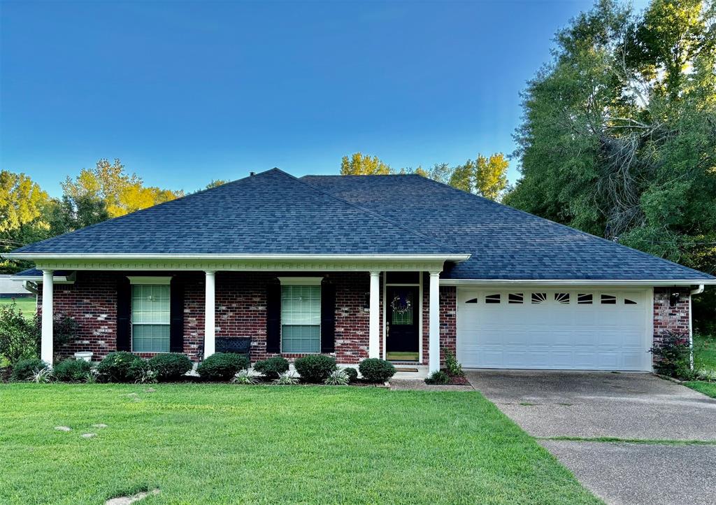 a view of brick house with a yard