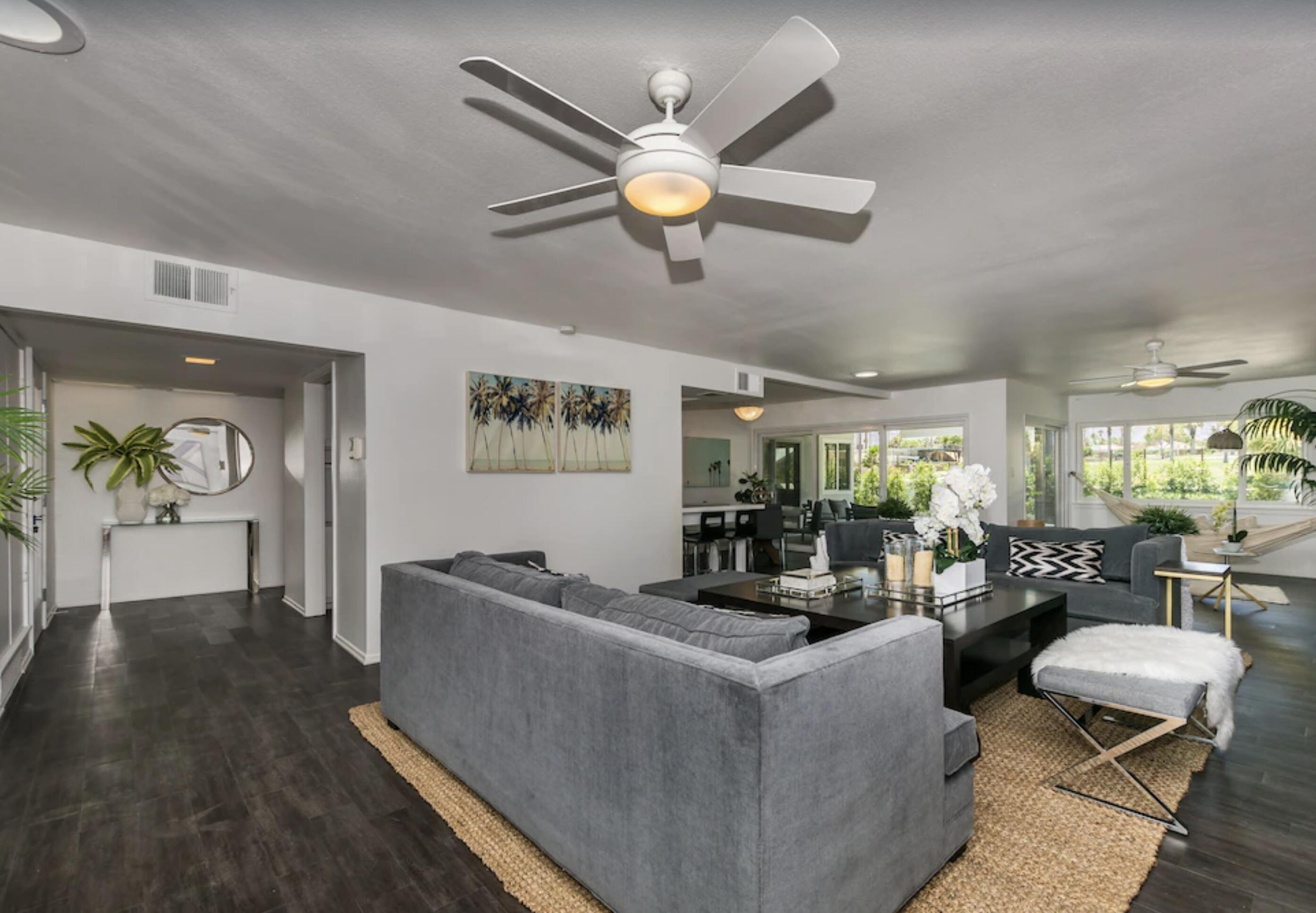 a living room with couches and pool with wooden floor